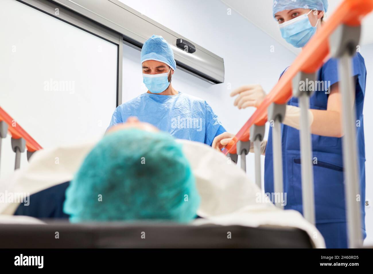 Surgeon and nurse on bedside with patient before operation in surgery