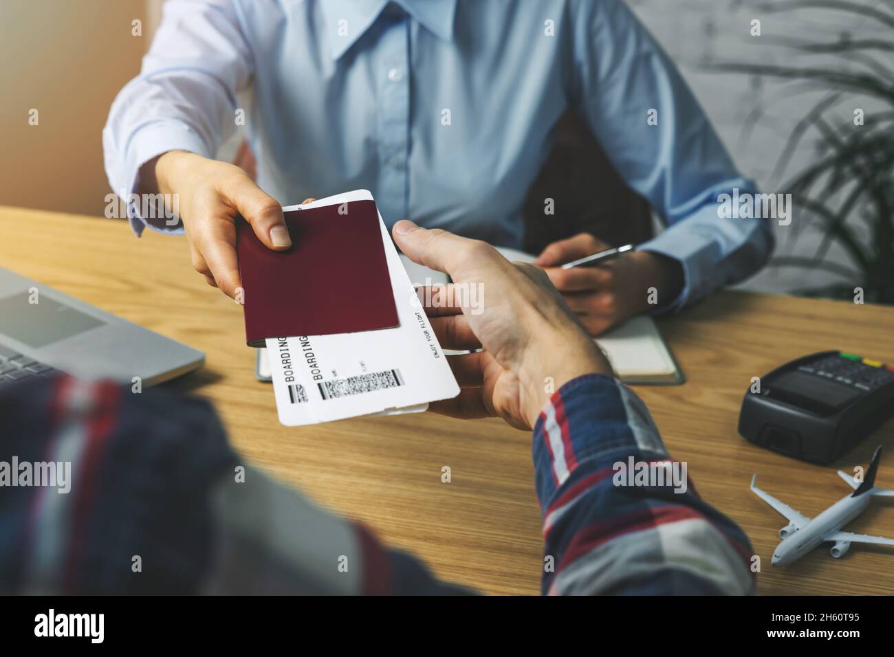 travel agent giving flight tickets and documents to customer in agency office Stock Photo
