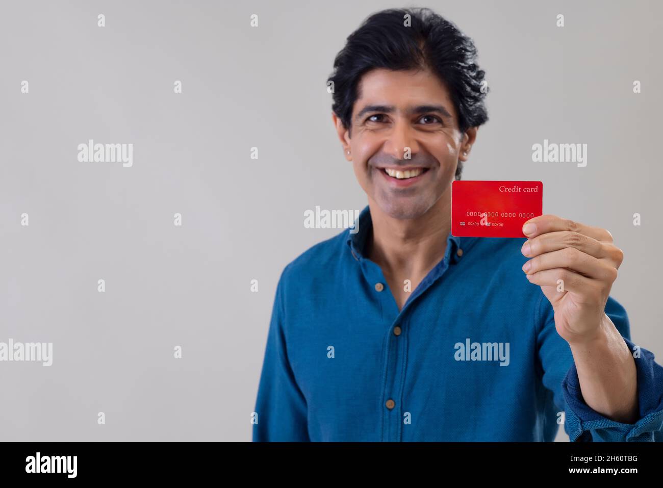 Indian man holding a credit card and posing in front of camera Stock ...