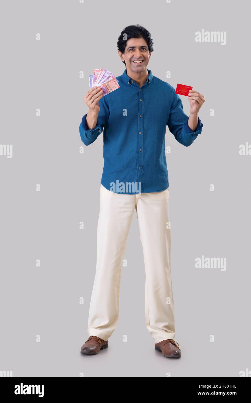 Indian man standing in front of camera with holding a credit card and ...