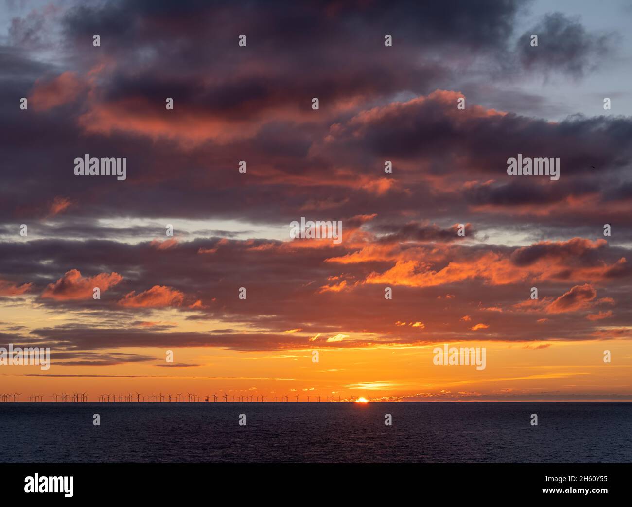 Sunset over English Channel with Rampion Wind Farm on the horizon. Stock Photo