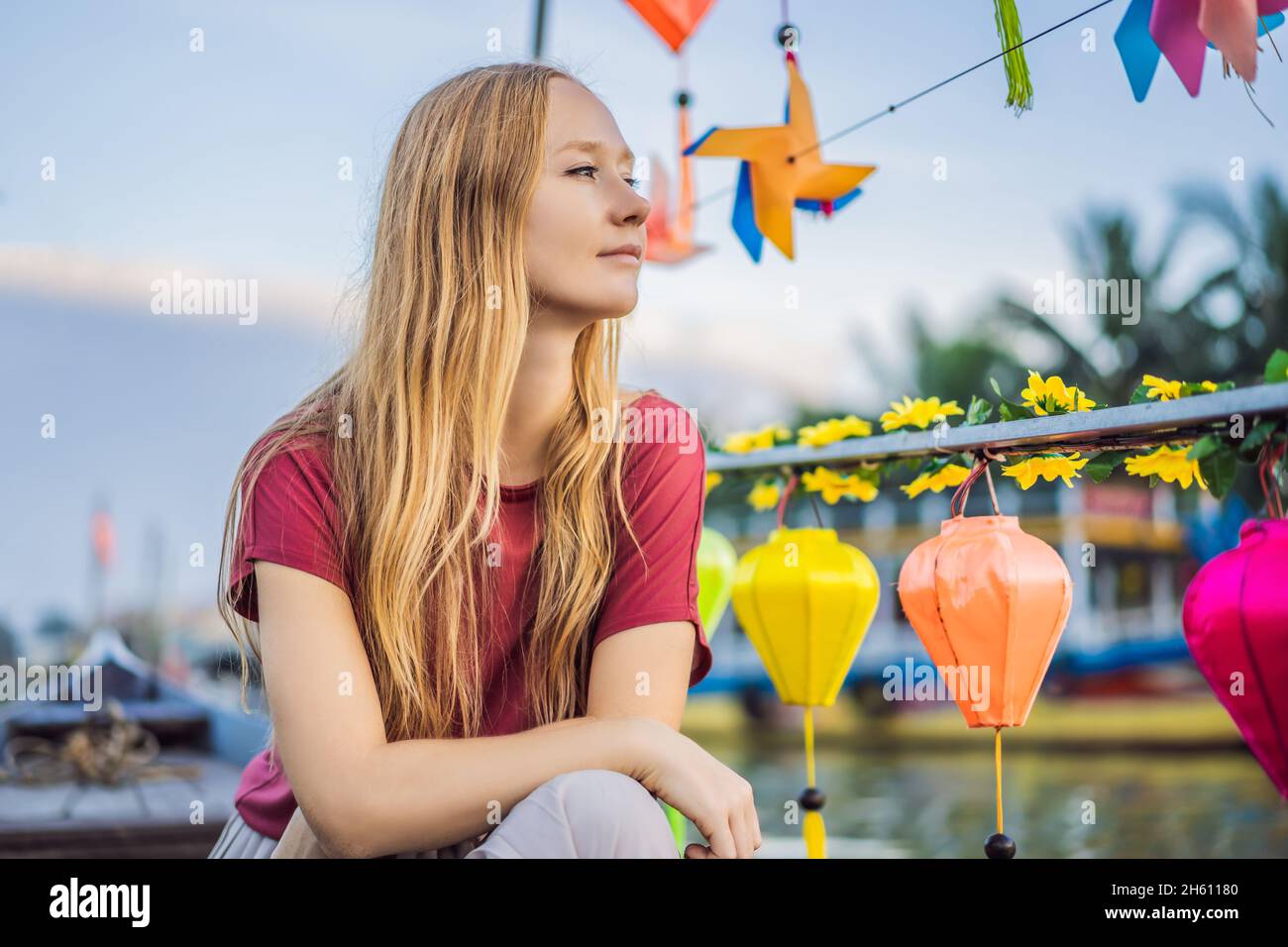 Happy woman traveler ride a national boat on background of Hoi An ...