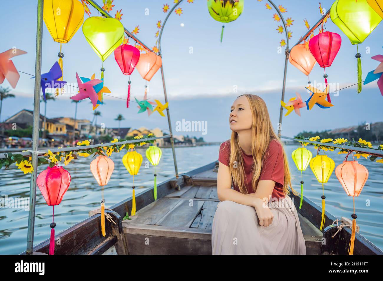 Happy woman traveler ride a national boat on background of Hoi An ...