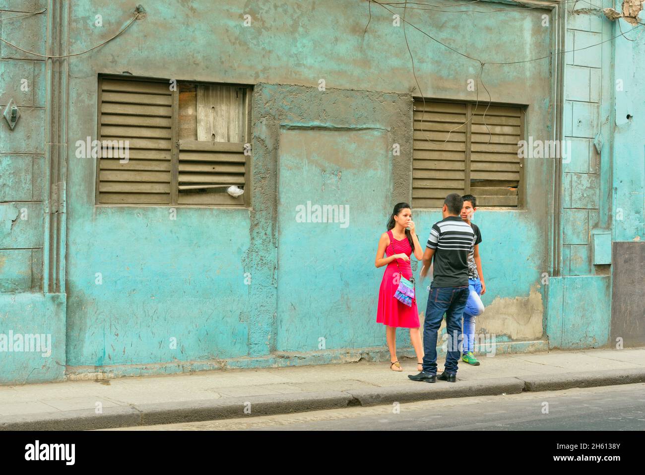Young Cubans in conversation on Calle Neptuno in Central Havana, La Habana (Havana), Habana, Cuba Stock Photo