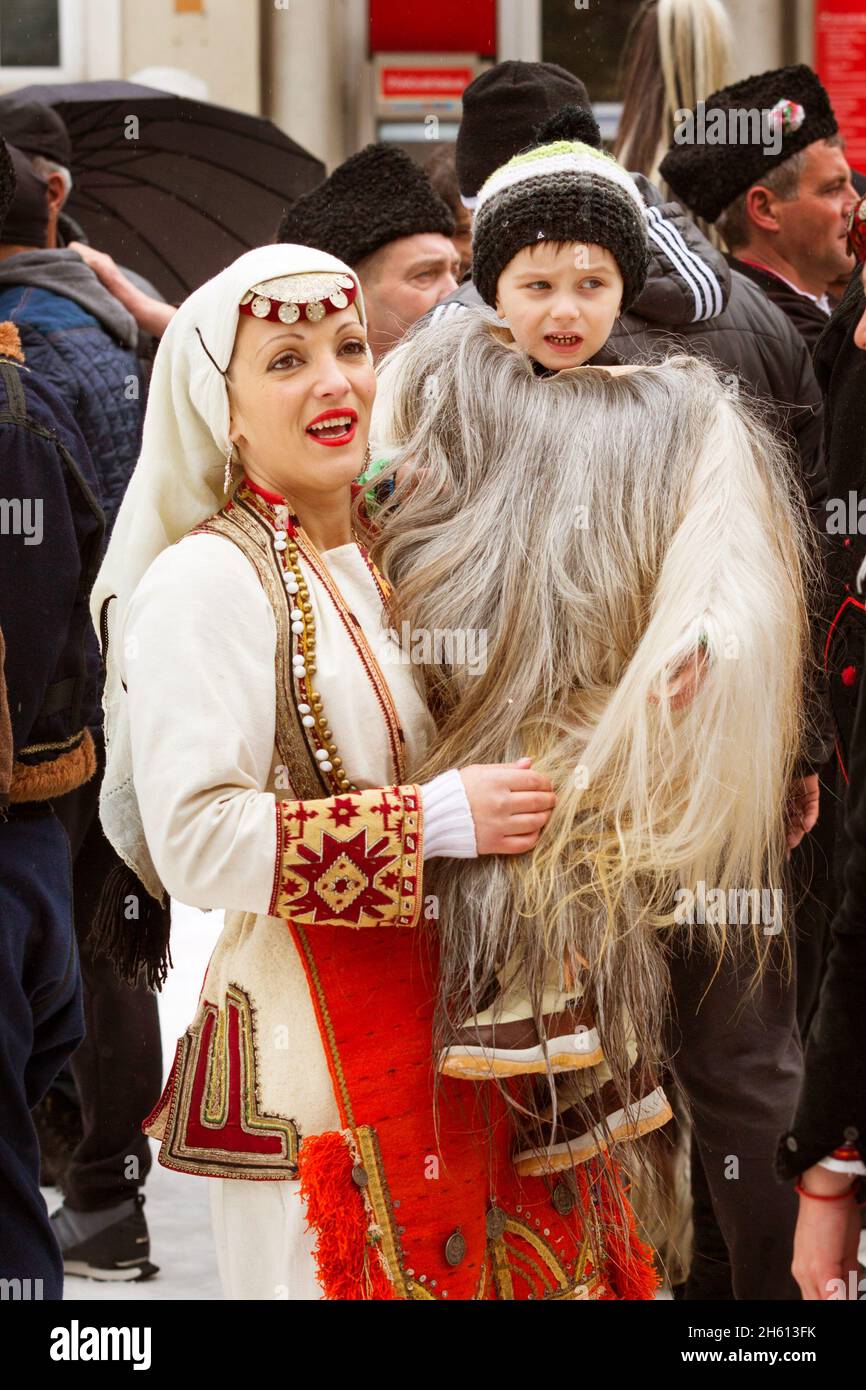 Razlog, Bulgaria - January 14, 2017: Mother and Child in traditional carnival kuker costume at bulgarian Kukeri festival Starchevata Stock Photo
