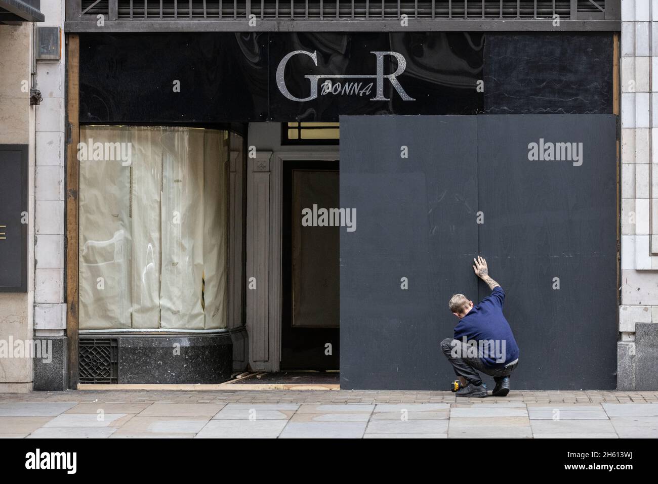 A high street store being boarded up on the Strand in central London, as high inflation and energy costs take their toll on small businesses, England. Stock Photo