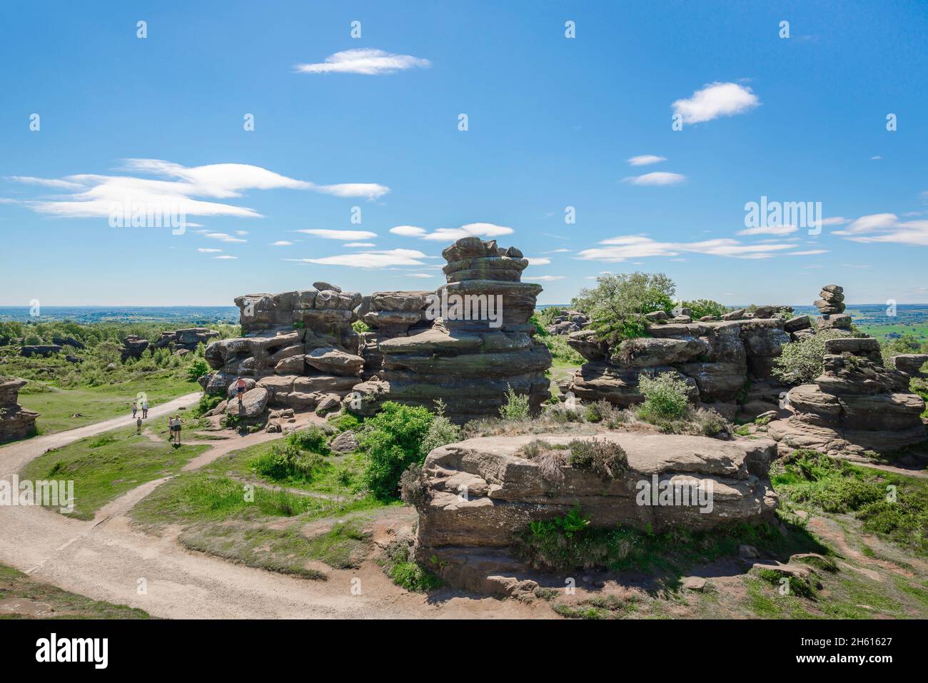 Metal Rocks England Yorkshire UK summer, view of people walking past heavily eroded rock ...