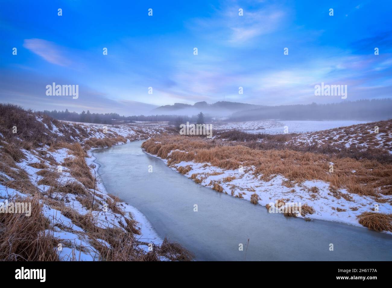 river with ice,snow and hills during sunrise Stock Photo