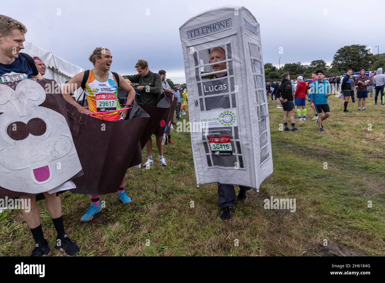 Fancy dress runners in various costumes ahead of the 2021 London Marathon congregate in Greewich Park before the race. Over 40,000 runners took part. Stock Photo