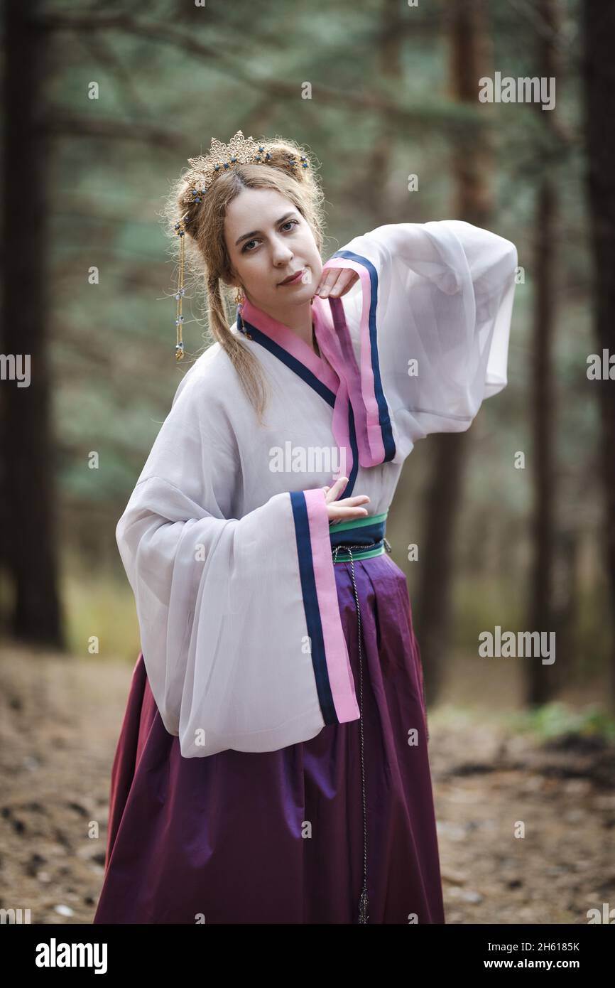 A nonChinese woman posing against the backdrop of an autumn forest
