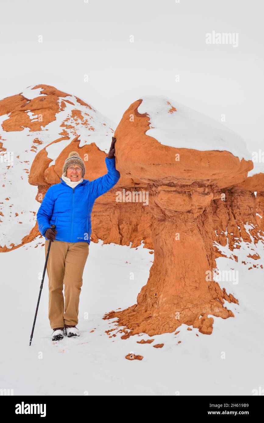 Visitor and the hoodoos in Goblin Valley with fresh snow, Goblin Valley State Park, Utah, USA Stock Photo