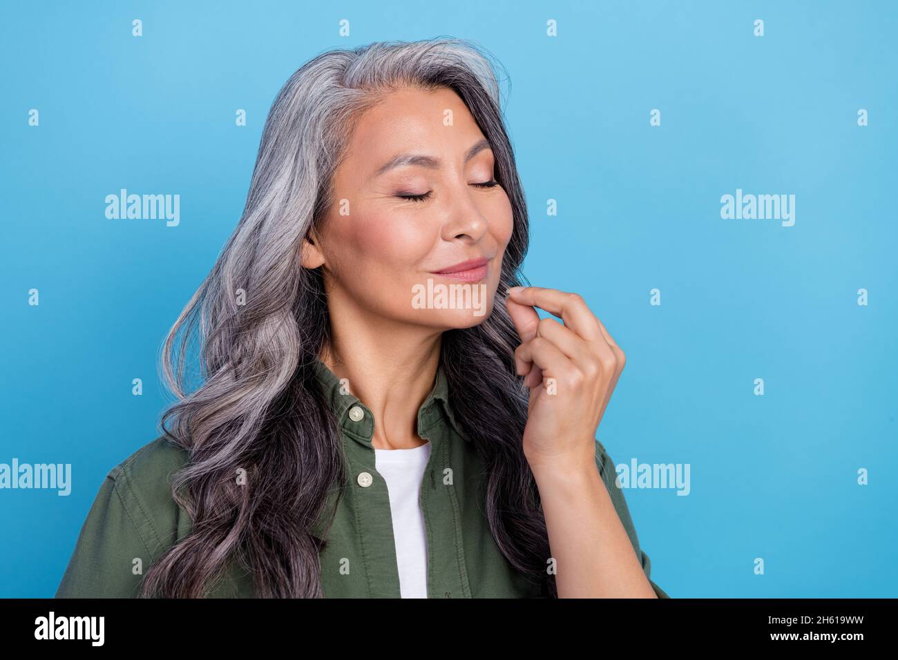 Photo of funny old white hairdo lady show tasty gesture wear green shirt isolated on blue color background Stock Photo