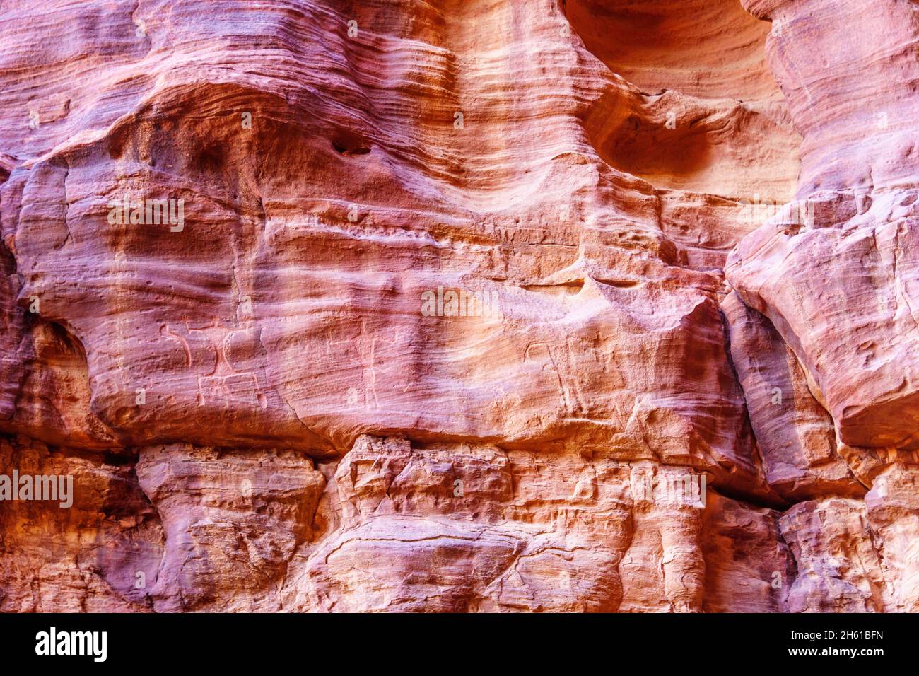 View of prehistoric petroglyphs and inscriptions in the rocks cliffs, Wadi Rum, desert park in Southern Jordan Stock Photo