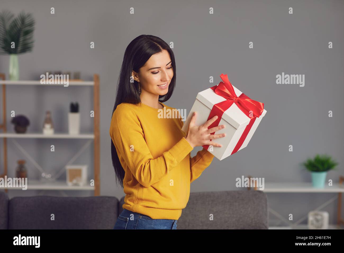 Charming woman holding present box with bow Stock Photo