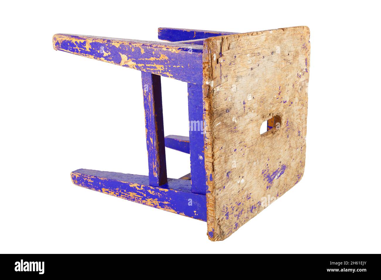 Old used wooden stool with peeling dark blue paint laid on its side