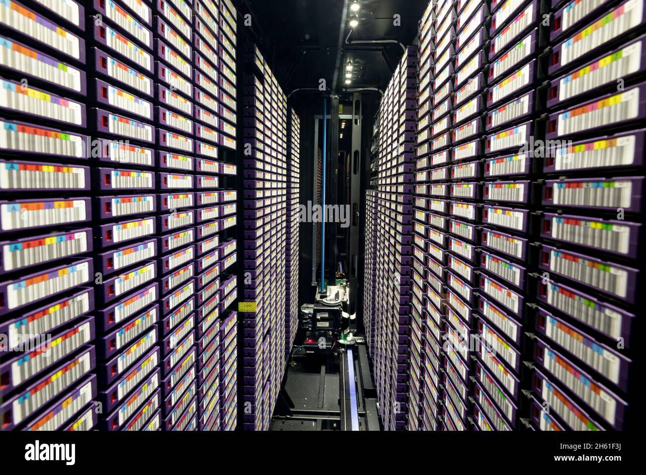 Data center with multiple rows of fully operational server racks Stock Photo