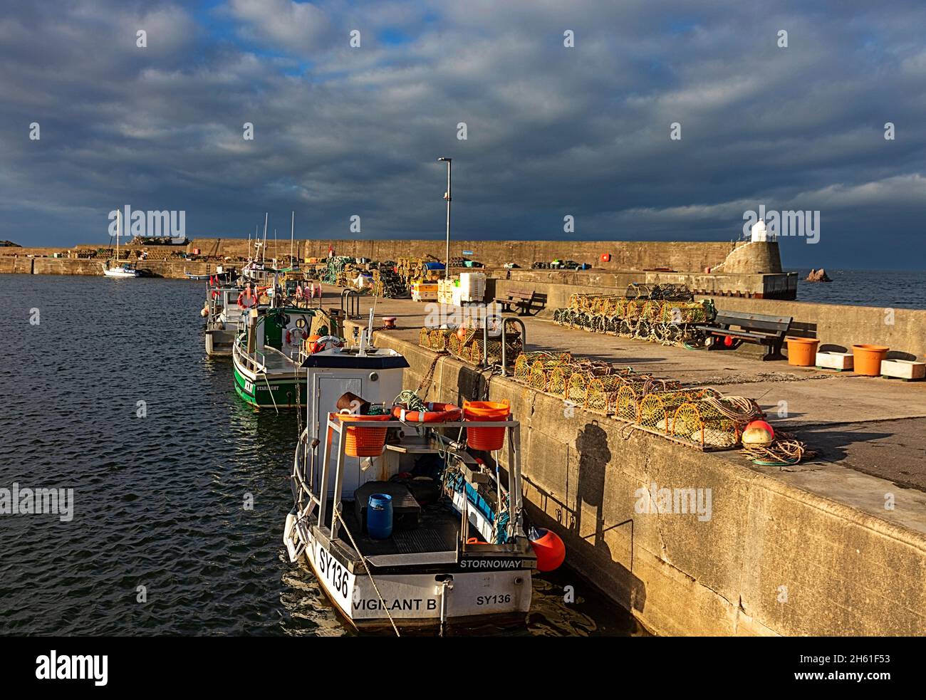 FINDOCHTY VILLAGE MORAY COAST SCOTLAND FISHING GEAR AND BOATS MOORED ALONGSIDE THE HARBOUR WALLS Stock Photo