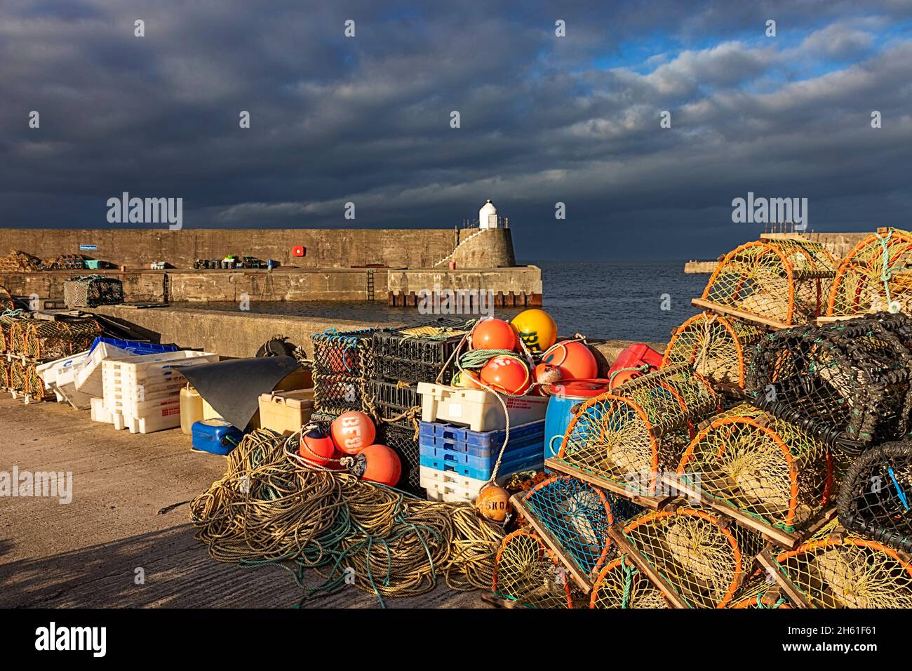 FINDOCHTY VILLAGE MORAY COAST SCOTLAND FISHING GEAR CREELS AND COLOURFUL FLOATS ON THE HARBOUR WALL Stock Photo