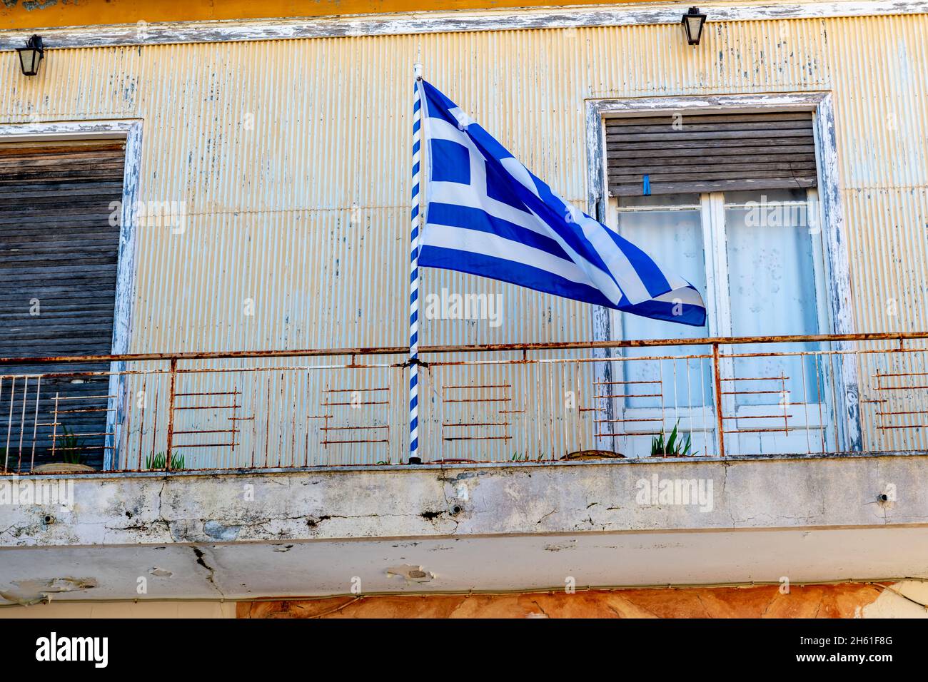 The Greek national Flag flying on the balcony of a building during the Oxi Day anniversary celebration in Lefkada, Greece. Stock Photo