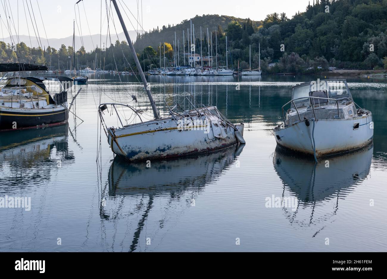 Broken derelict sailing boats in shallow waters. Stock Photo