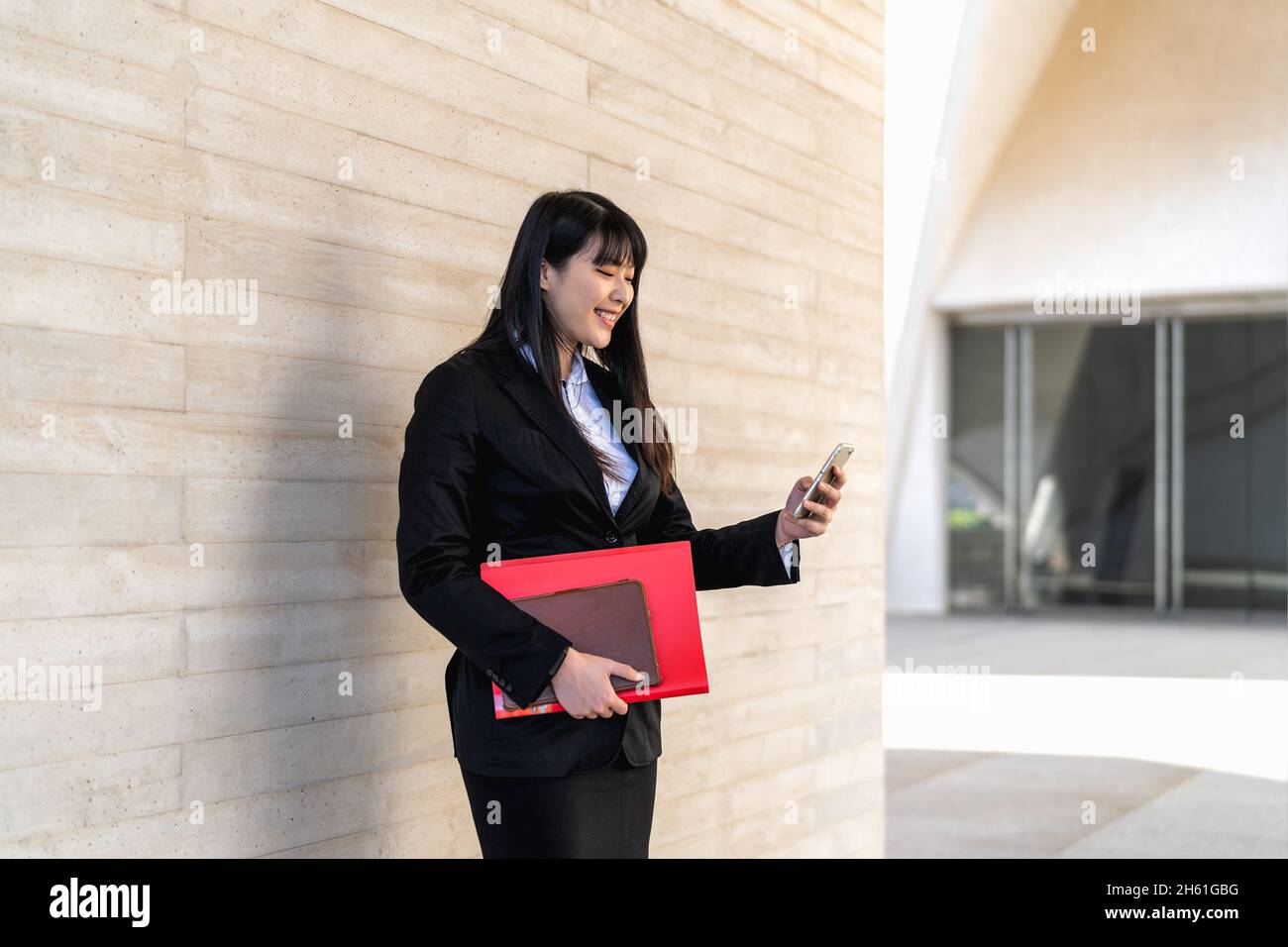 Asian business woman using mobile smartphone out the office - Entrepreneurship concept Stock Photo