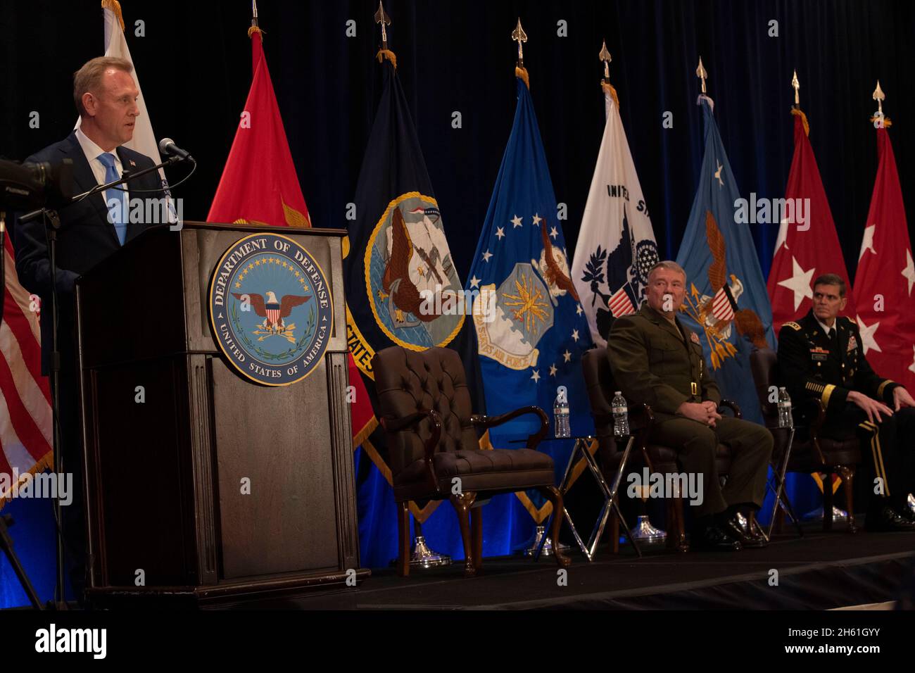 Reportage:   U.S. Acting Secretary of Defense Patrick M. Shanahan speaks at the U.S. Central Command change of command, Tampa, Florida, March 28, 2019. Seated are (center) the incoming commander of U.S. Central Command, U.S. Marine Corps Gen. Kenneth F. McKenzie Jr., and the outgoing Centcom commander, U.S. Army Gen. Joseph L. Votel. Stock Photo