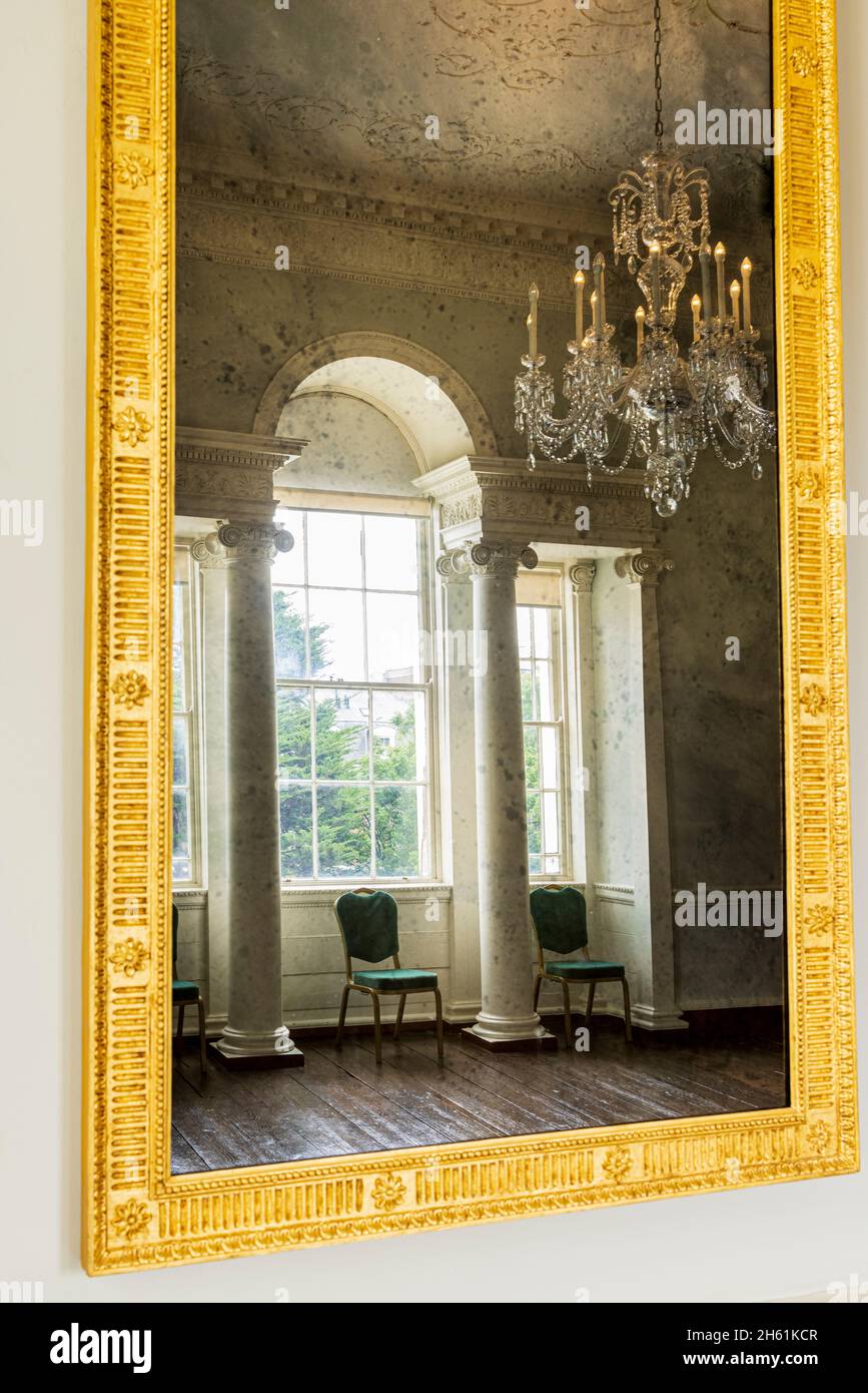Gilt framed mirror with mottling reflecting a room and window in Rathfarnham Castle, Dublin, Ireland Stock Photo