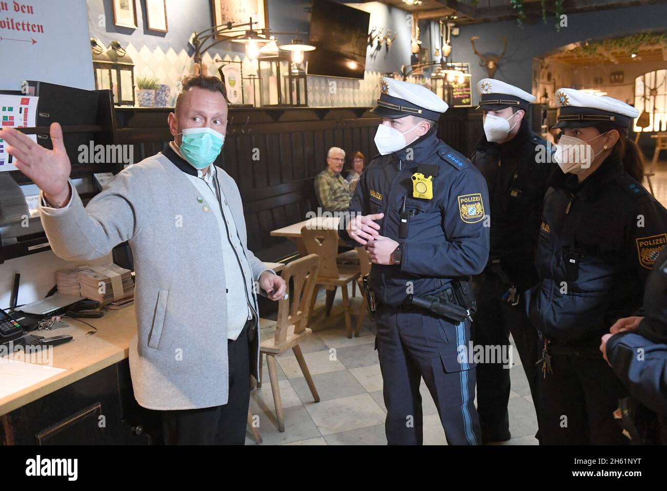 Munich, Germany. 12th Nov, 2021. Police officers talk to restaurant manager Bardis Jason (l) during a press event on Corona controls in Munich, Germany, to check compliance with Corona rules in front of the media. Credit: Felix Hörhager/dpa/Alamy Live News Stock Photo