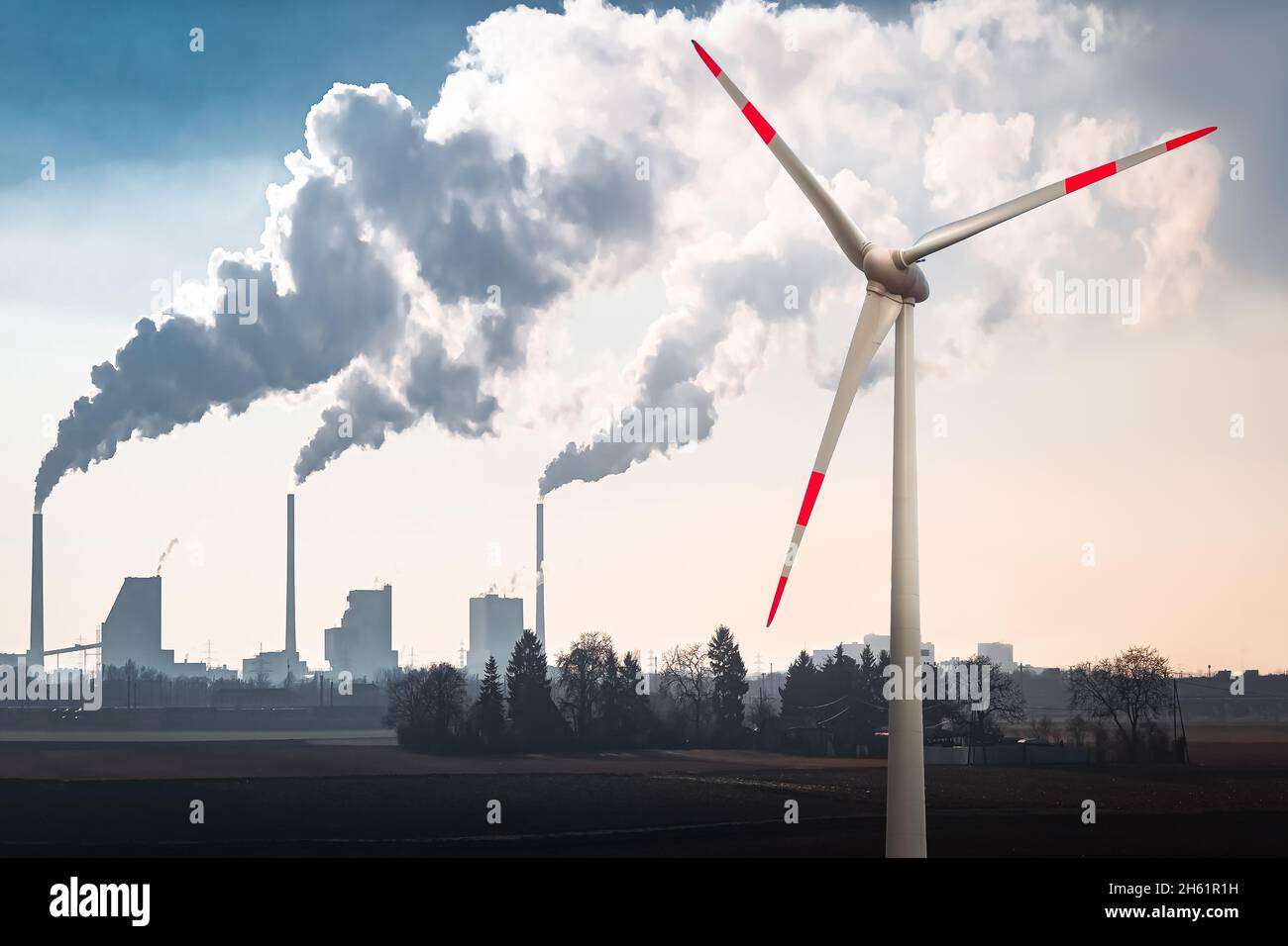 Landscape with a Wind Turbine and the Smoke Stacks of a Coal Fired Power Plant in the Background Stock Photo
