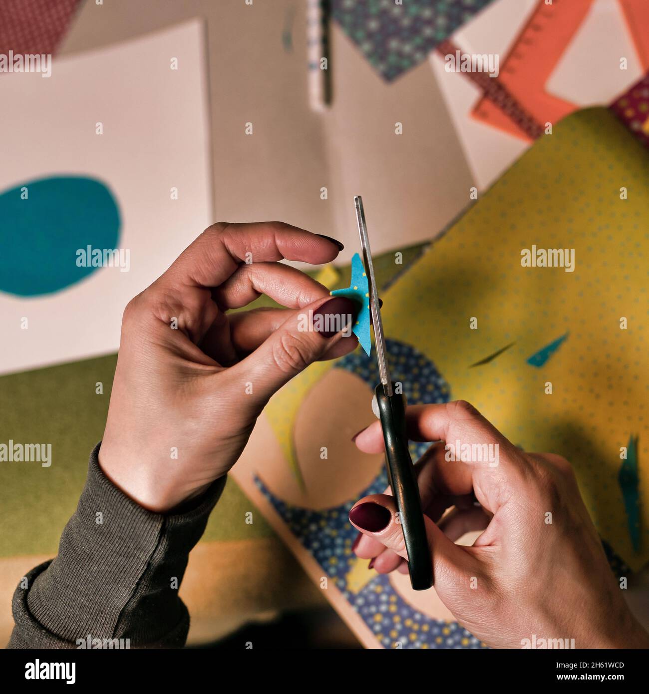 the process of cutting paper with scissors. scissors in female hands close-up Stock Photo