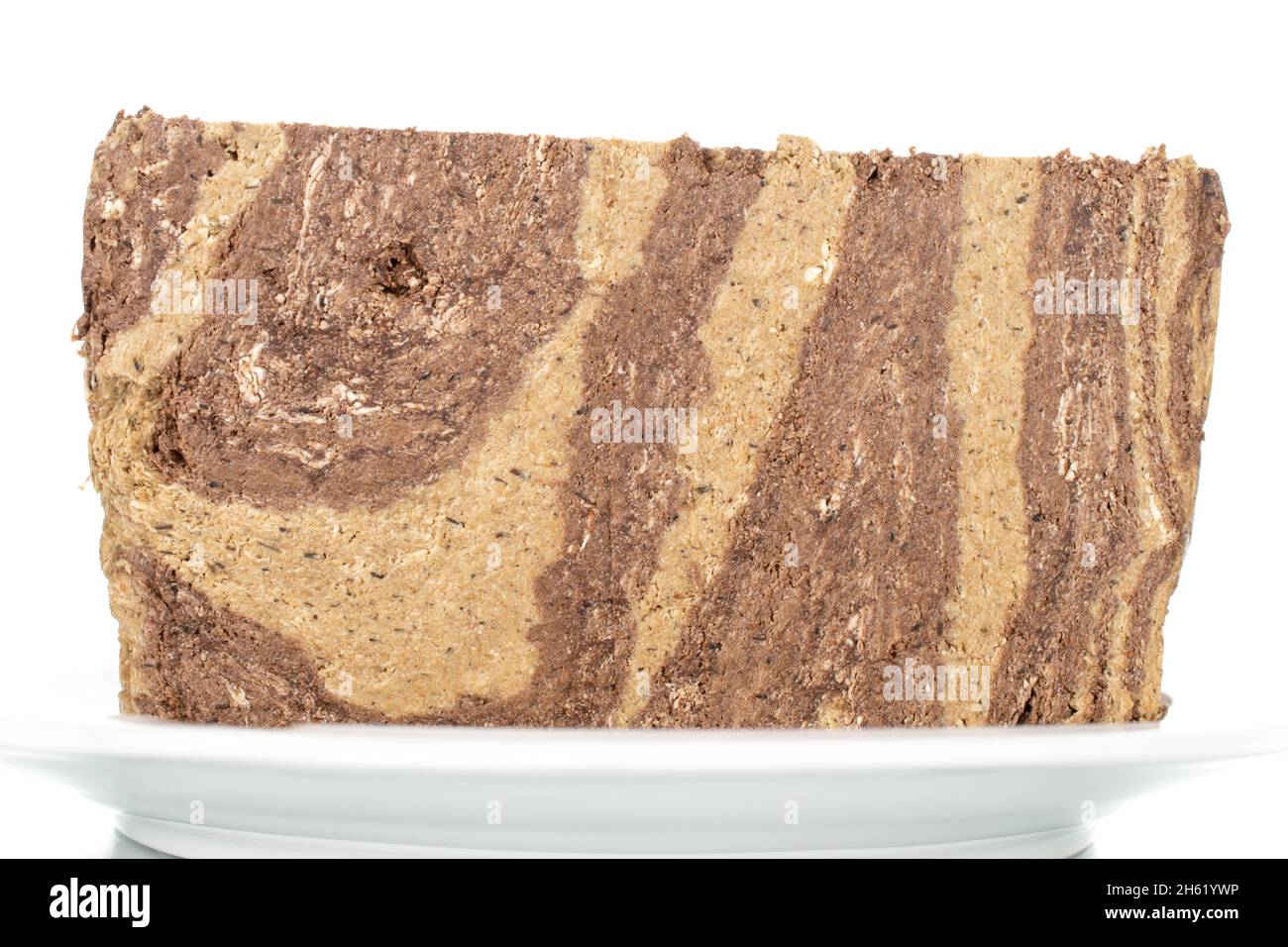 Pieces of sweet halva with chocolate on a white saucer, closeup