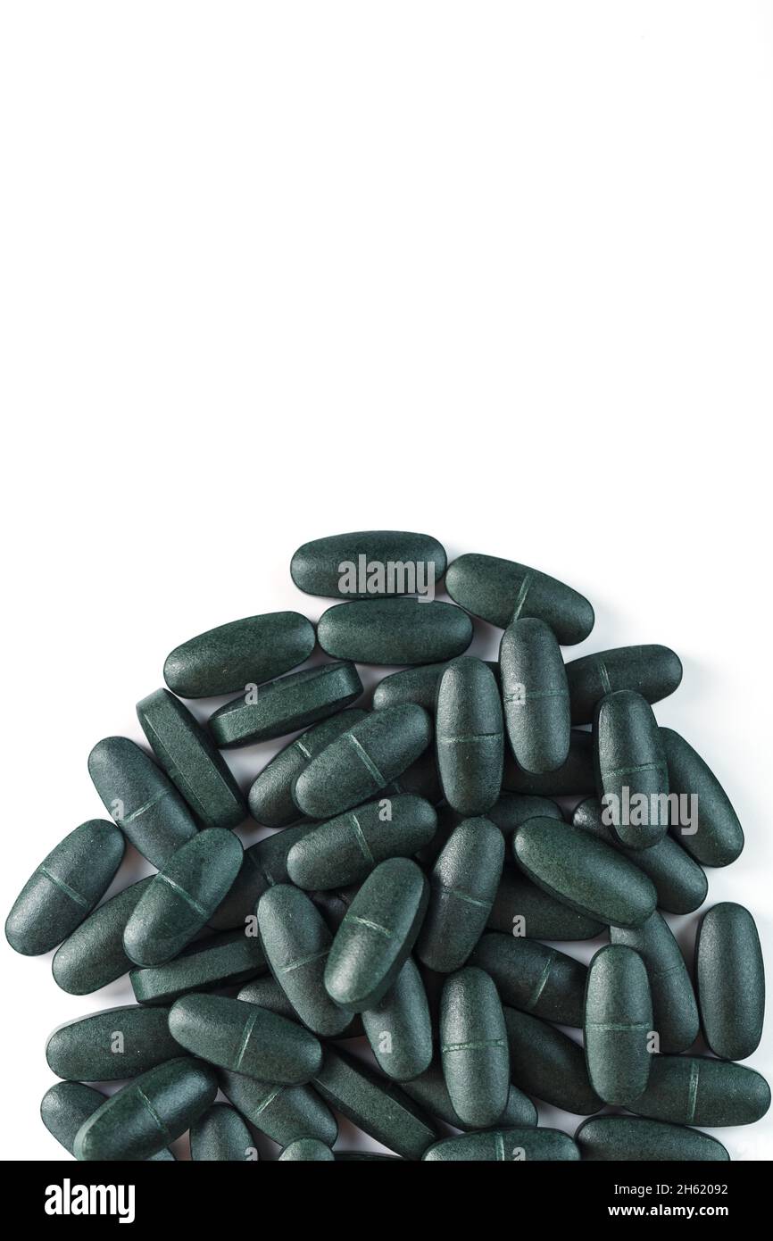 Green spirulina pills with multivitamins on a white background. Free space Stock Photo Alamy