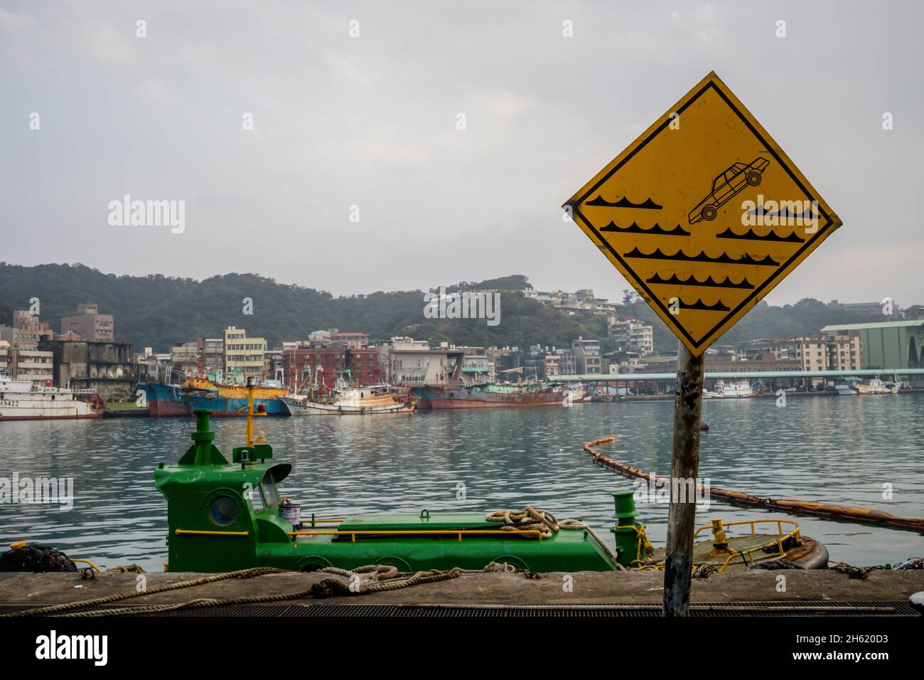 freighter and danger of falling sign in the harbor in heping,northern taiwan Stock Photo