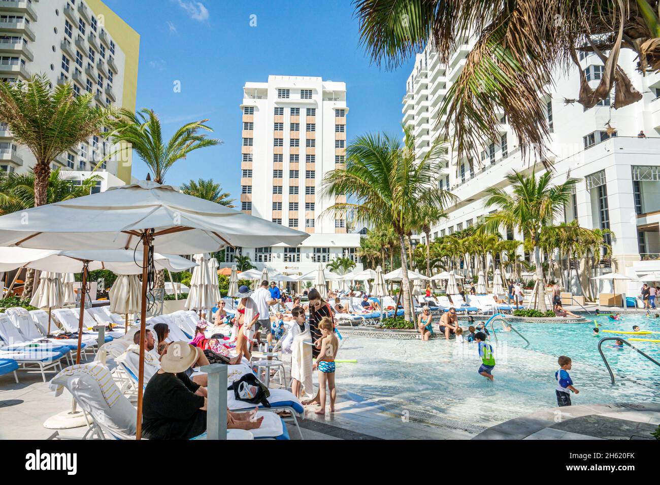 Miami Beach Florida,Loews St. Moritz swiming pool children umbrellas guests Stock Photo
