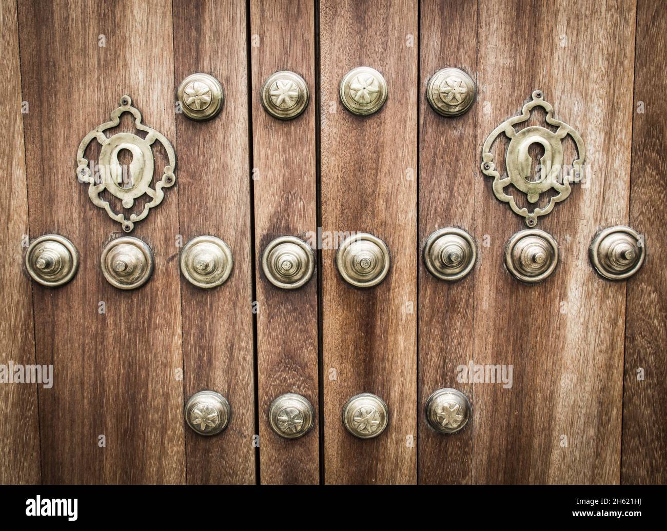 Golden round rivets on brown wood door background. Entrance closed, no entry concepts Stock