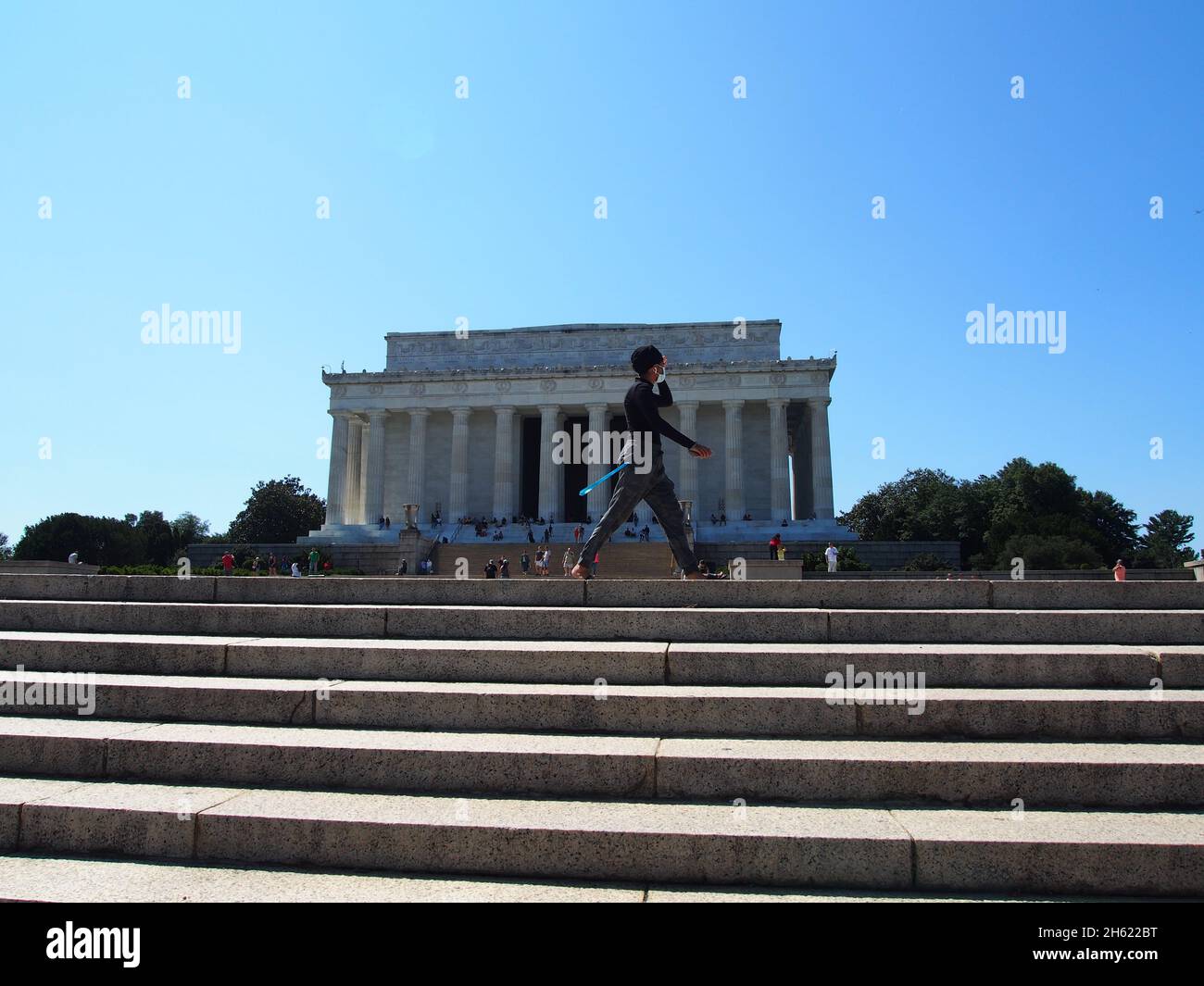 Masked woman exercise walking past the Lincoln Memorial in Washington, D.C., USA, 2021 © Katharine Andriotis Stock Photo