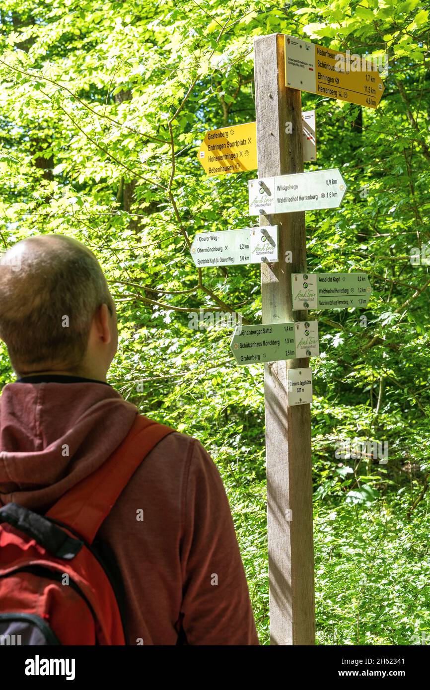 europe,germany,baden-wuerttemberg,schönbuch region,herrenberg,hiker looks confused at the madness of signs Stock Photo