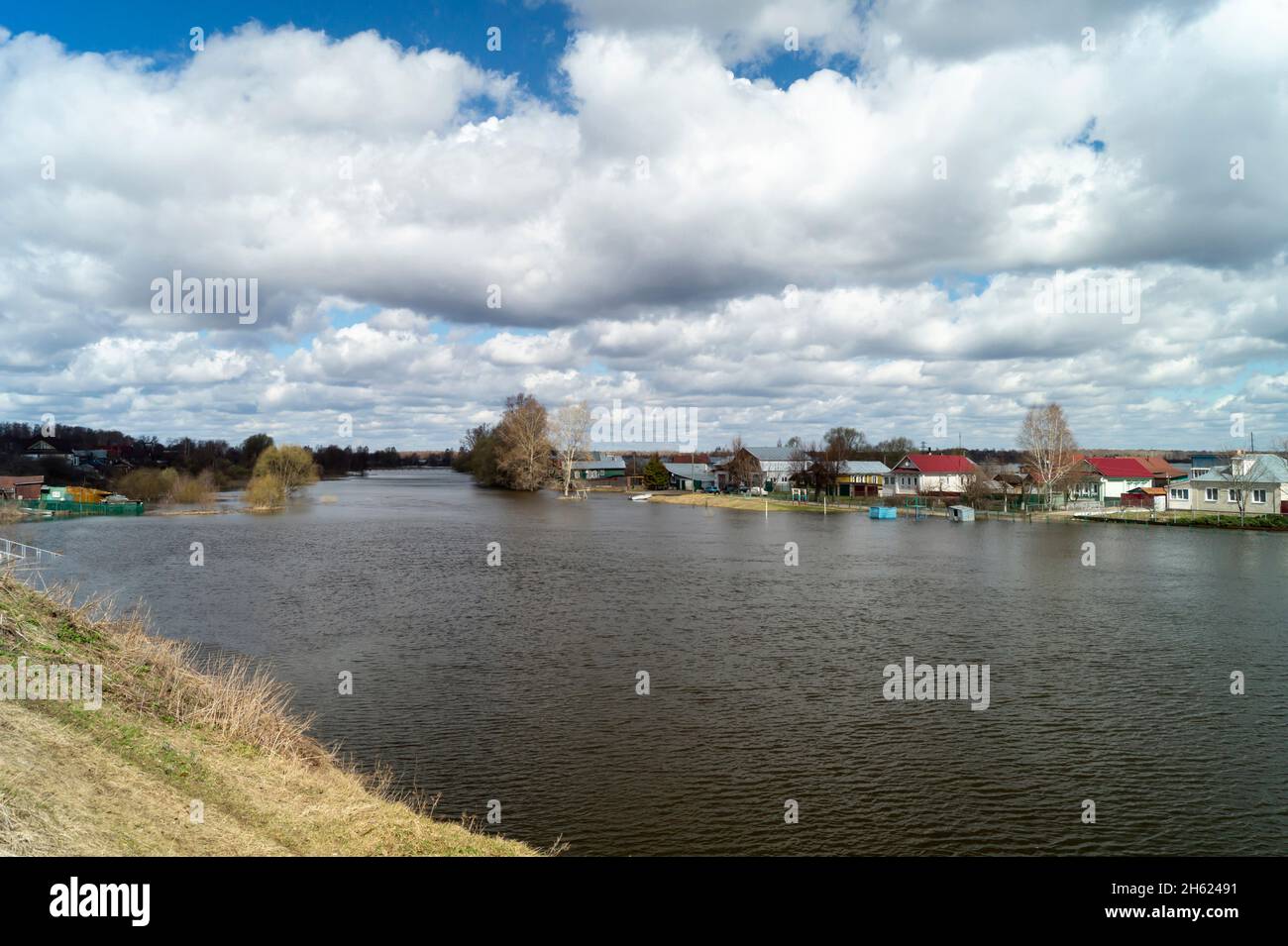 Spring flood in rural terrain on background blue sky with white cloud Stock Photo