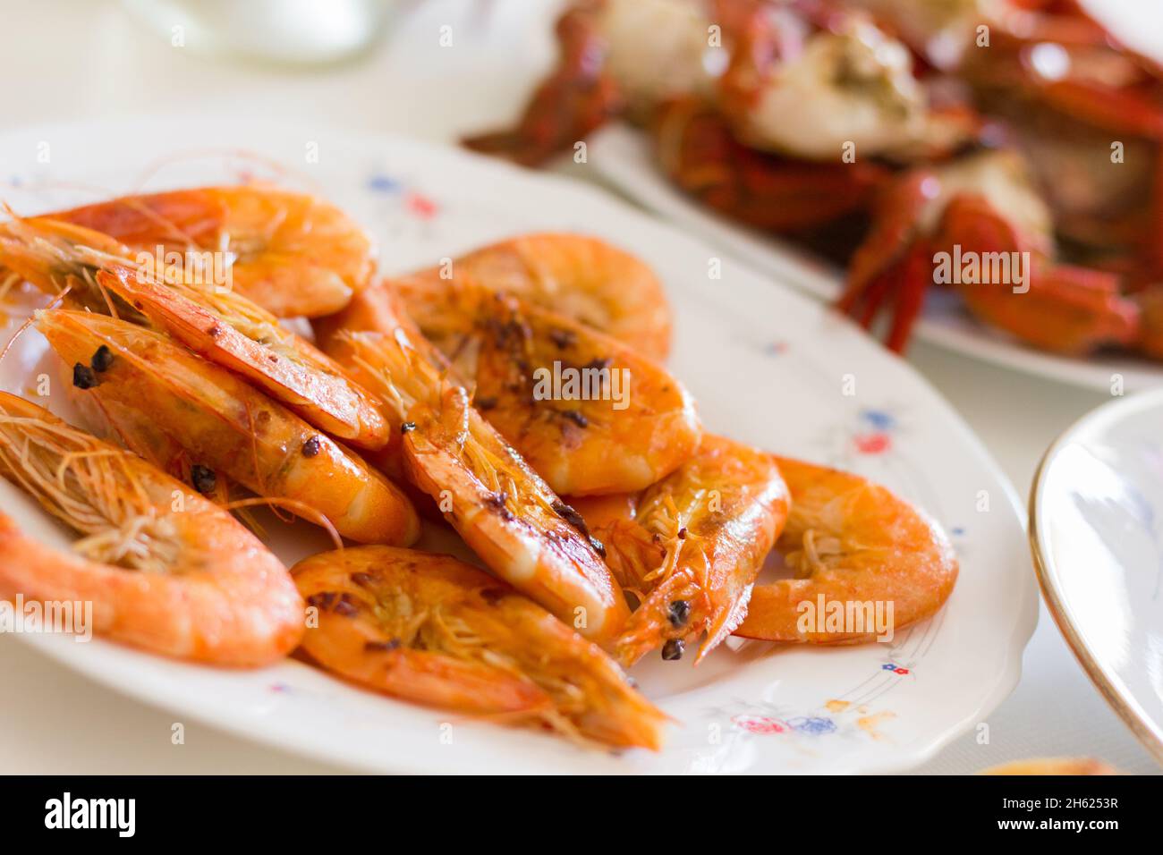 Grilled prawns plate. Fried shrimps appetizer dish. Crab legs on background, seafood dinner concept Stock Photo