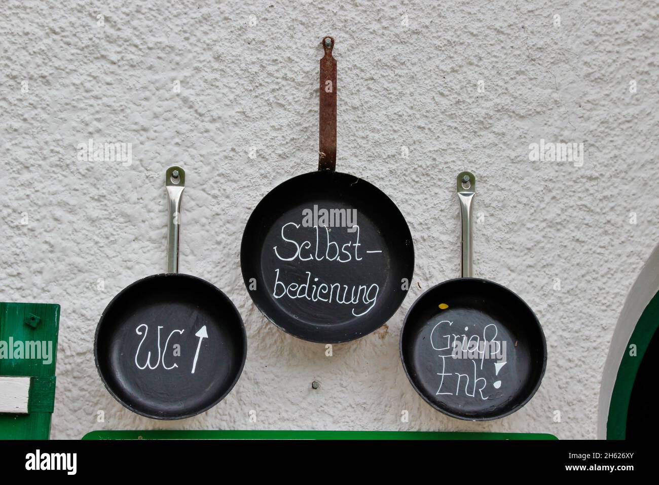 frying pans,pans on the house wall of the pfeishütte,1922 m goetheweg,toilet,self-service,greeting 'griaß enk',excursion destination via innsbruck also accessible via scharnitz,gleirschtal,samertal,karwendel nature park,karwendel mountains,innsbruck,tyrol,austria,europe, Stock Photo