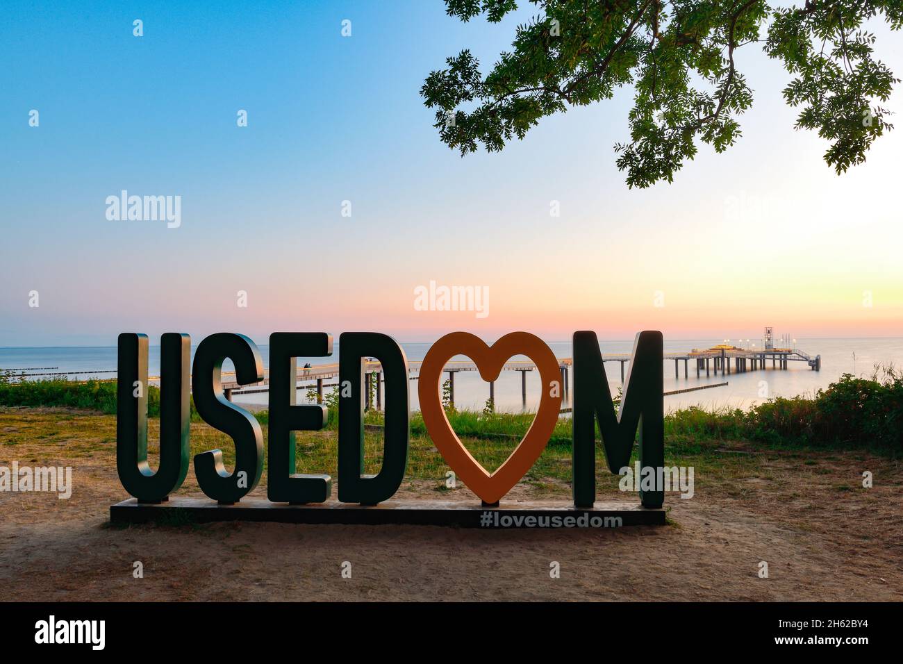 view of the construction of the pier in koserow on usedom,which opened in 2021,at sunrise with the usedom advertising in the foreground Stock Photo