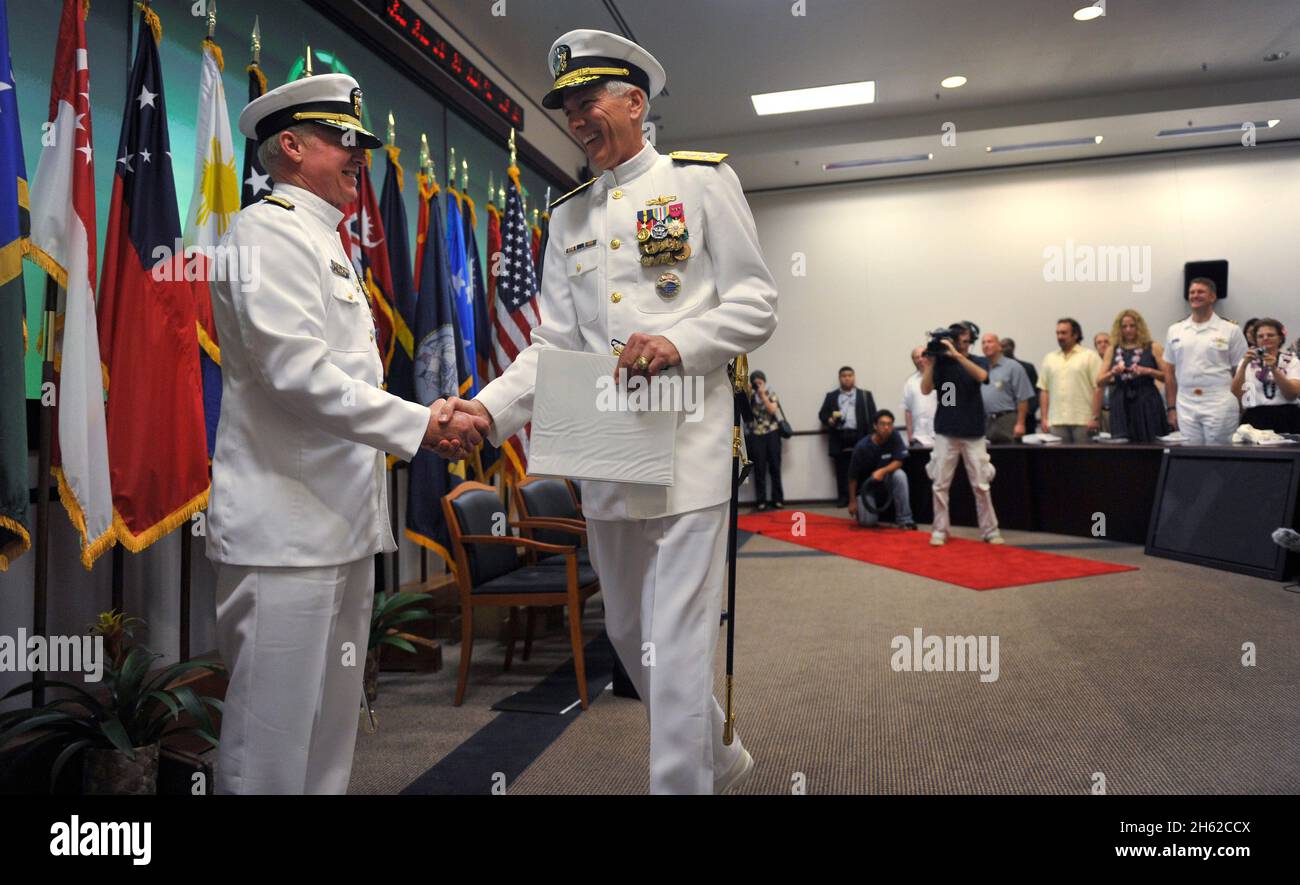 U.S. Navy Adm. Robert F. Willard, left, the outgoing commander of U.S. Pacific Command, shakes hands with incoming commander Adm. Samuel J. Locklear III during a change of command ceremony at the Nimitz-MacArthur Pacific Command Center at Camp H.M. Smith, Hawaii, March 9, 2012 Stock Photo
