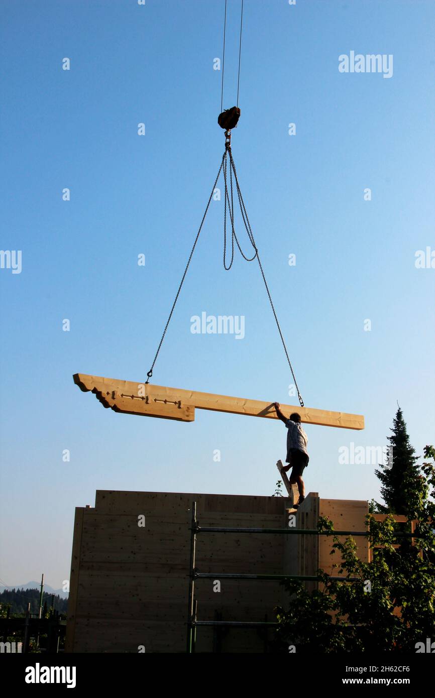 construction workers using wooden beams for roof trusses in timber ...