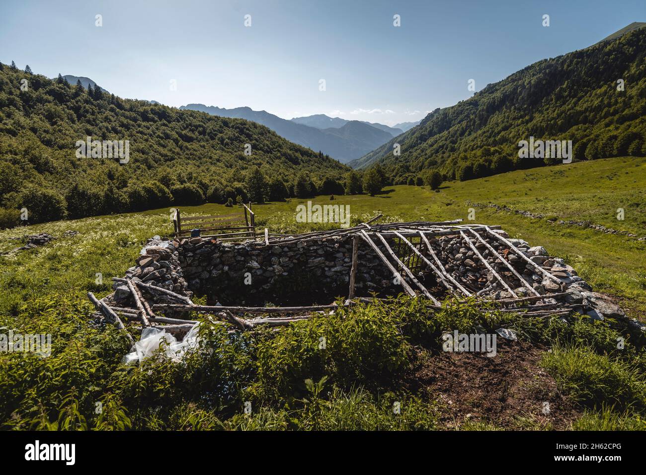 remains of an old,stone building in the middle of a green pasture,montenegro,prokletije national park Stock Photo