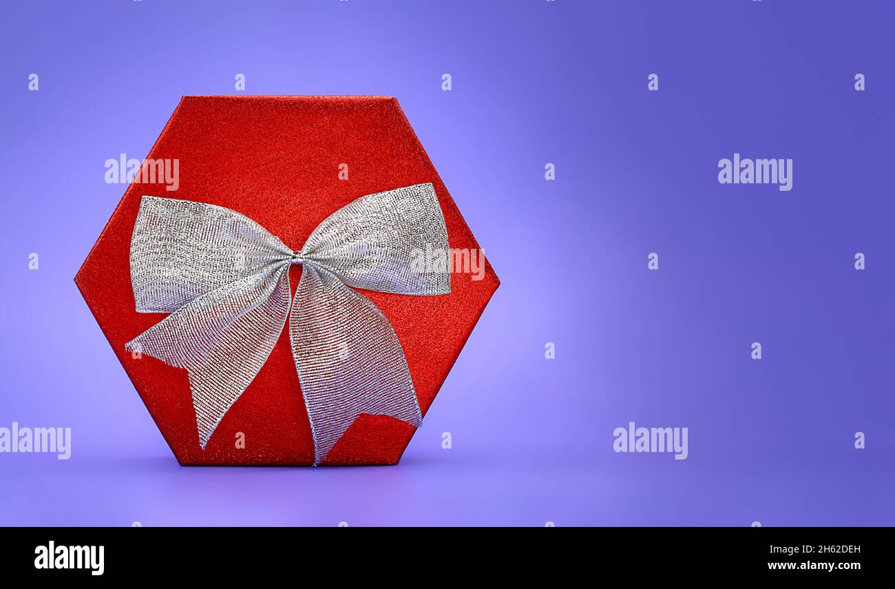 Big shiny red box with silver bow on lilac background. Present. Christmas, New Year, Mother's , Father's , International Women's Day, March 8, Birthda Stock Photo