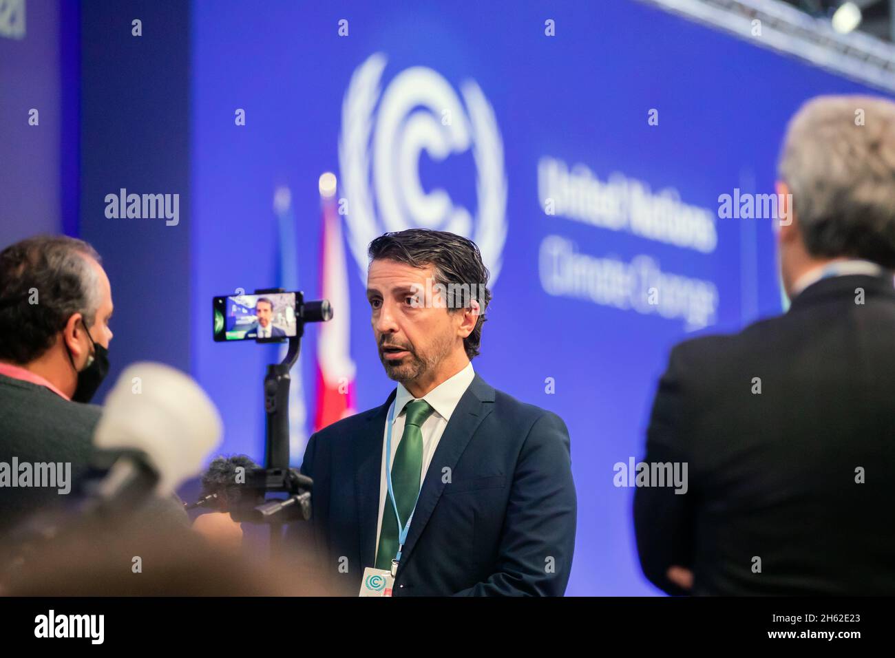 Glasgow, UK. 12th Nov, 2021. Joaquim Alvaro Pereira Leite, Minister of Environment of Brazil, speaks to a journalist's smartphone during a break in the session at the UN Climate Change Conference COP26. The world climate conference is taking place in Glasgow. Around 200 countries are negotiating how to curb the global climate crisis and global warming. Credit: Christoph Soeder/dpa/Alamy Live News Stock Photo
