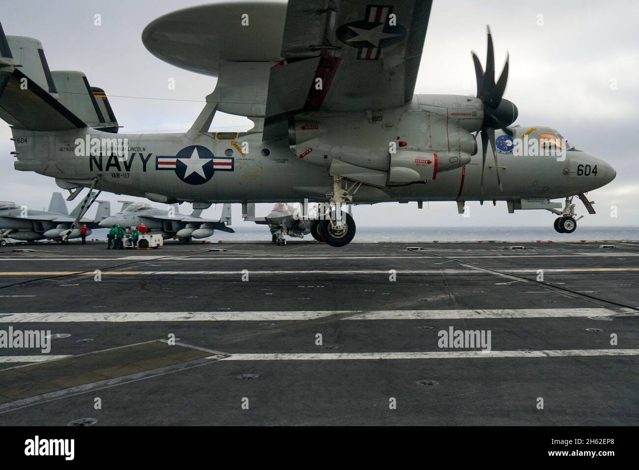 A E-2D Hawkeye early warning and detection aircraft lands on the deck of a United States Navy aircraft carrier Stock Photo