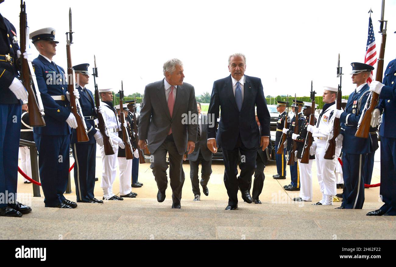 Secretary of Defense Chuck Hagel, left, escorts Greece’s Minister of National Defense Dimitris Avramopoulos, right, through an honor cordon and into the Pentagon in Arlington, Va. July 30, 2013. Stock Photo