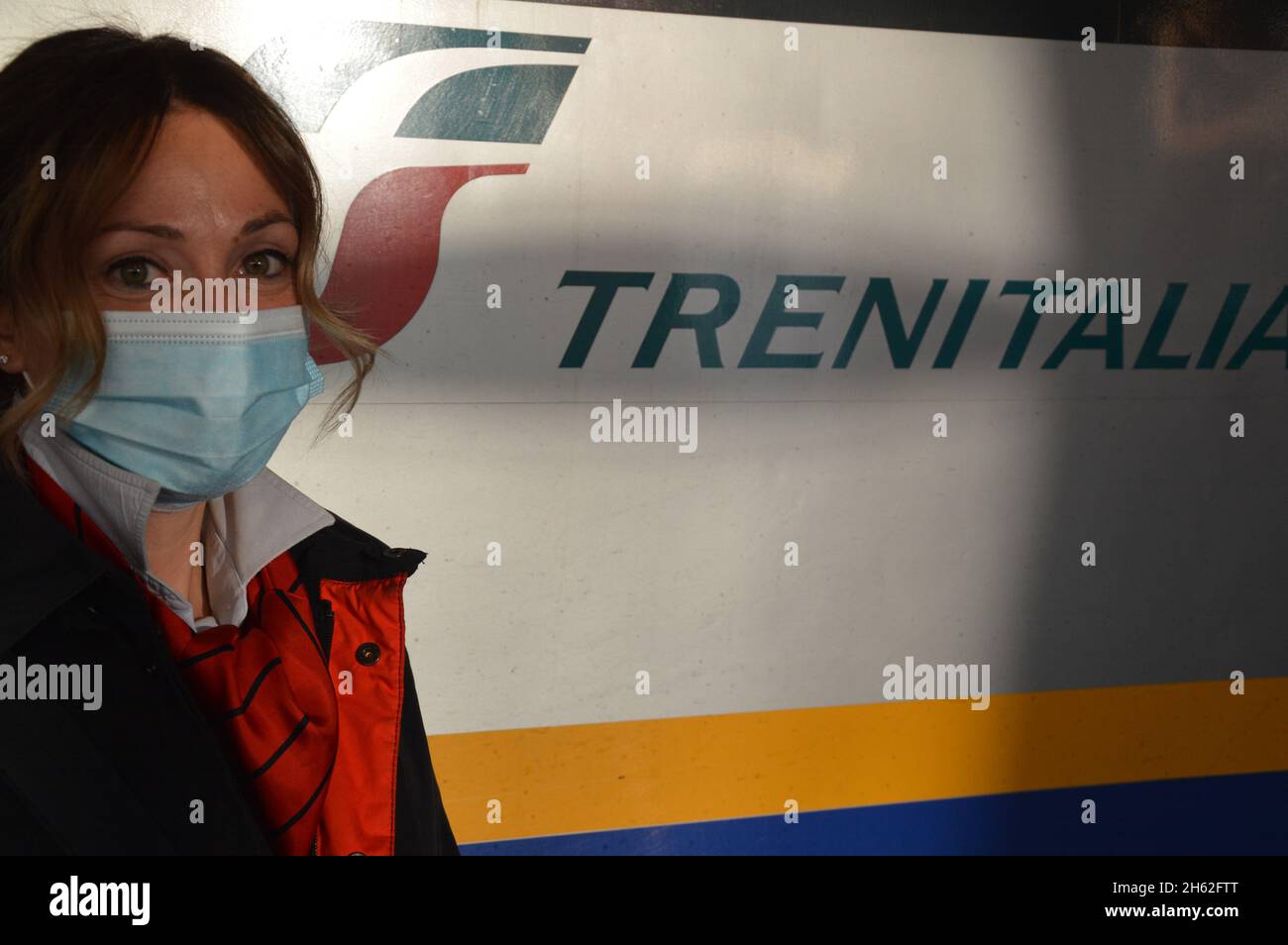 Trenitalia female train staff member wearing face mask at Venezia Santa Lucia railway station in Italy - November 11, 2021. Stock Photo