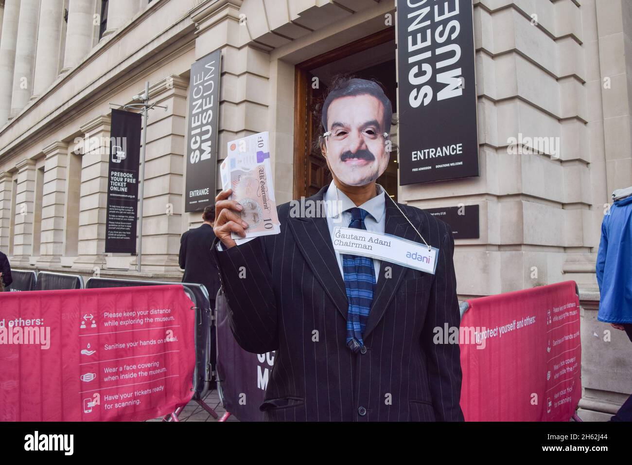 London, UK. 12th Nov, 2021. A protester dressed as Adani chairman Gautam Adani holds fake money during the demonstration.Extinction Rebellion demonstrators gathered outside the Science Museum in South Kensington, as part of their ongoing protests against sponsorship of the museum by fossil fuel companies Shell and Adani. (Photo by Vuk Valcic/SOPA Images/Sipa USA) Credit: Sipa USA/Alamy Live News Stock Photo
